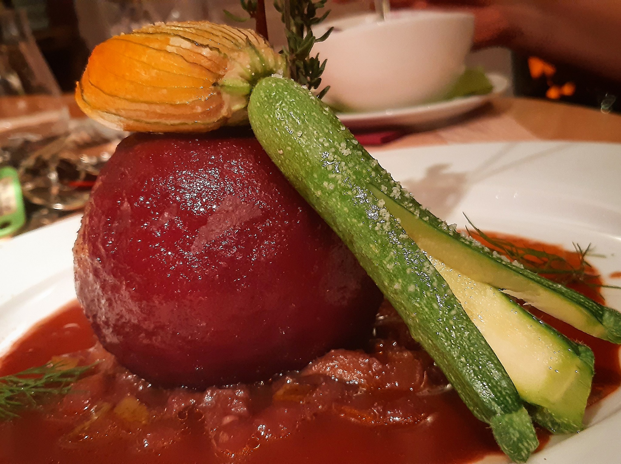 "Roter Riese & Sternschnuppe" Roter »Gefillder« mit Maronen-Ricotta-Kern an Zucchiniblüte gefüllt mit Hokkaido-Kürbis & Kerbel auf würziger Sauce von der karamellisierten Rotweinbirne